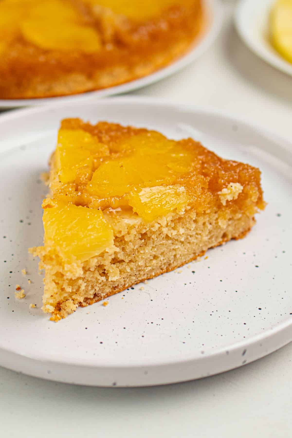 Close-up of pineapple-topped slice of homemade pie on white plate.