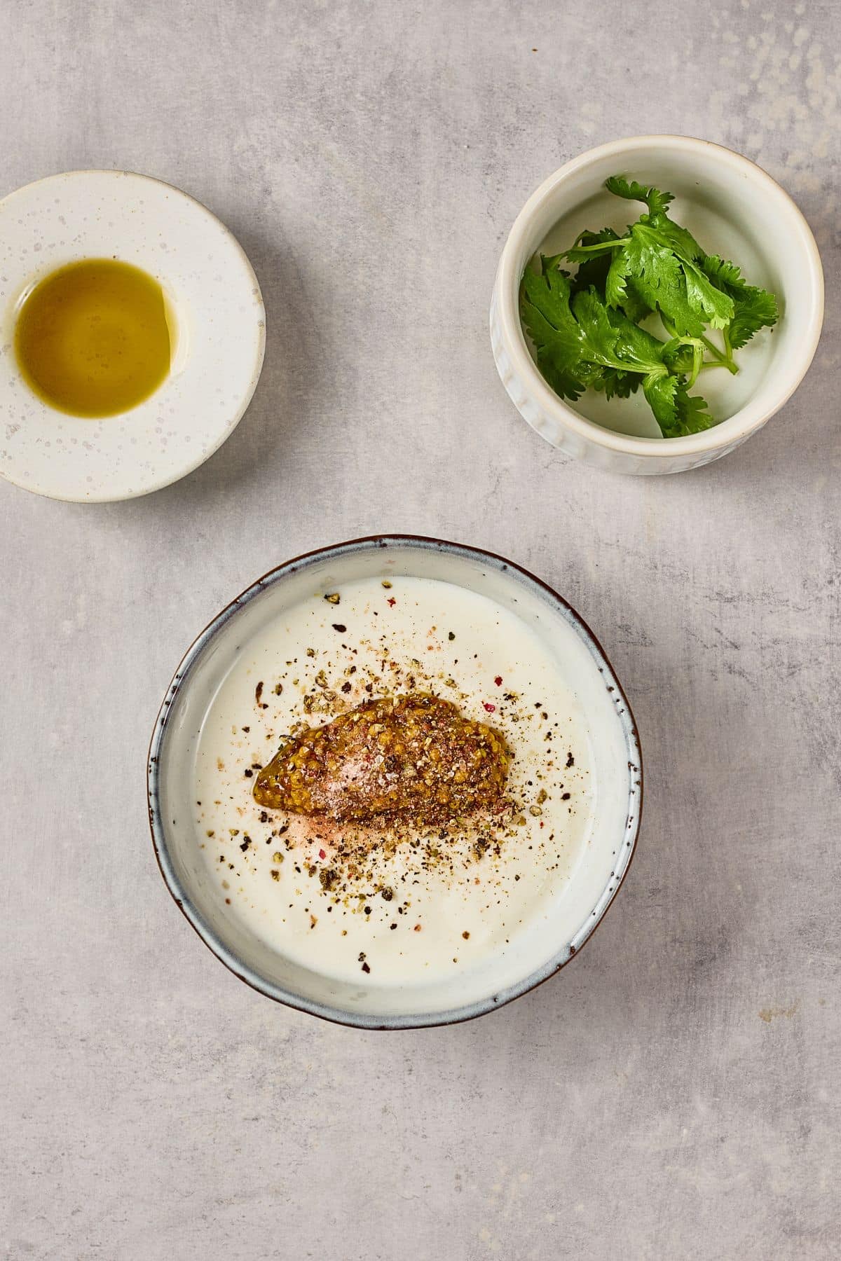 Delicious yogurt dip topped with herbs and spices, served with olive oil and fresh cilantro.