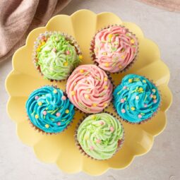 Bright, fun cupcakes decorated with pink, green, and blue frosting and colorful sprinkles.