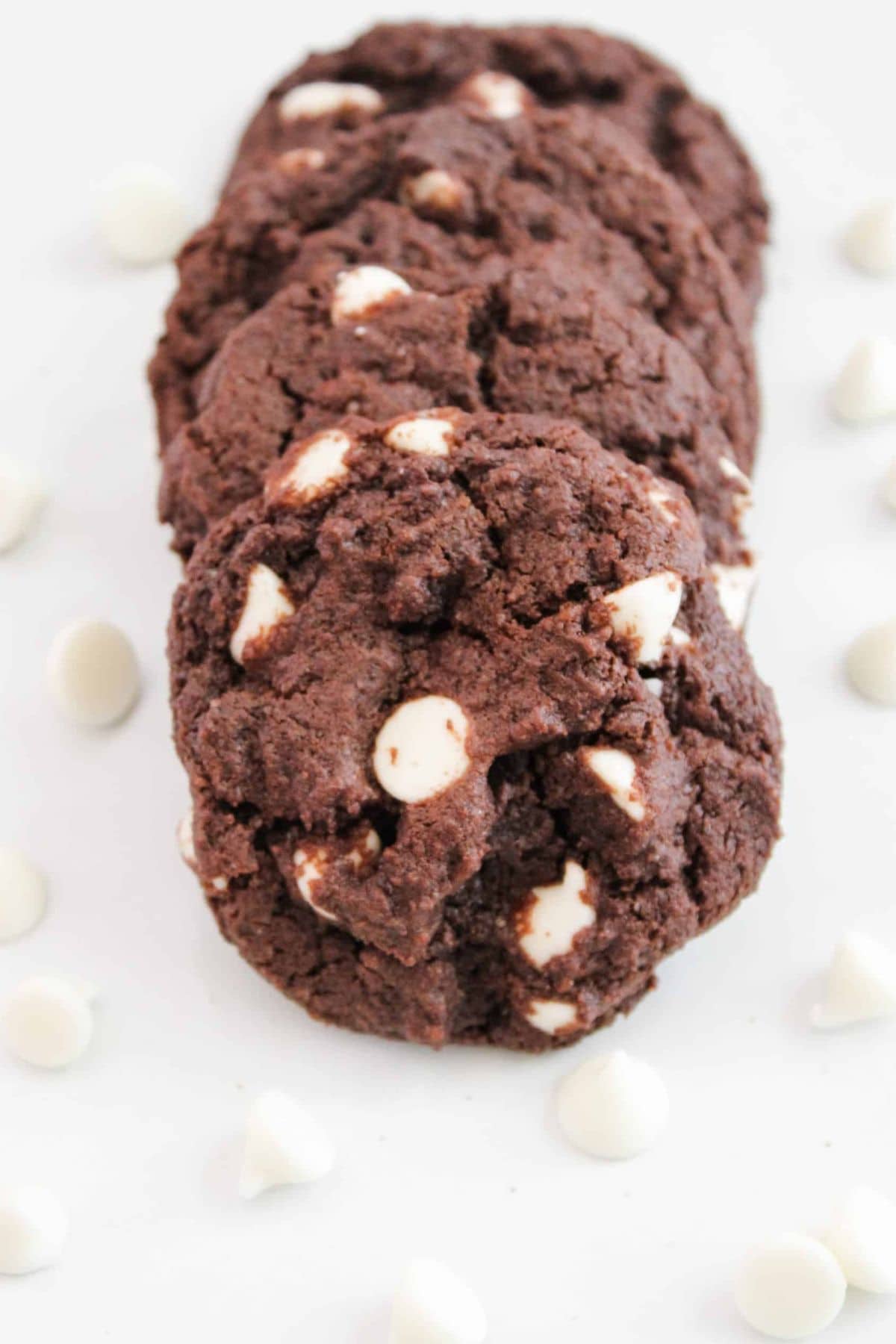 White chocolate cookies on a surface, surrounded by white chocolate kisses.