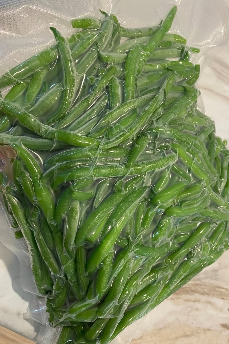 Vacuum-sealed bag filled with blanched green beans, ready for freezing