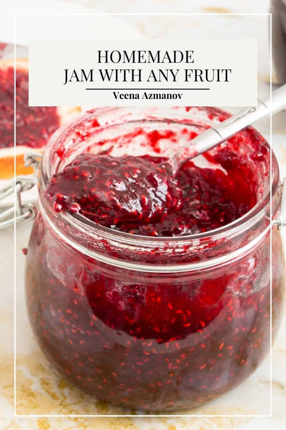 Spoon scooping dark red jam from a glass jar. A slice of bread with jam is visible in the background.