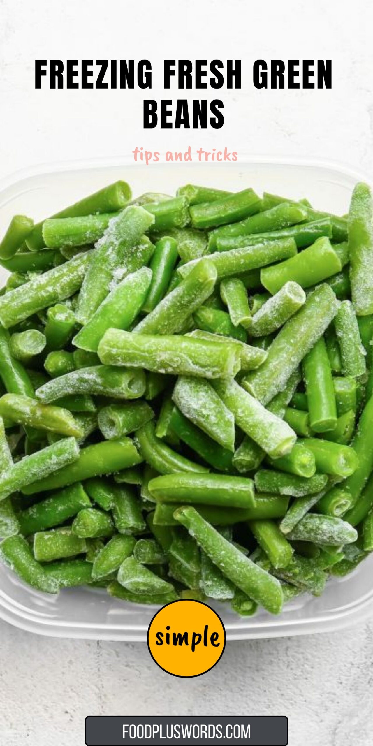 Frozen cut green beans with frost on them, in a clear rectangular storage container.