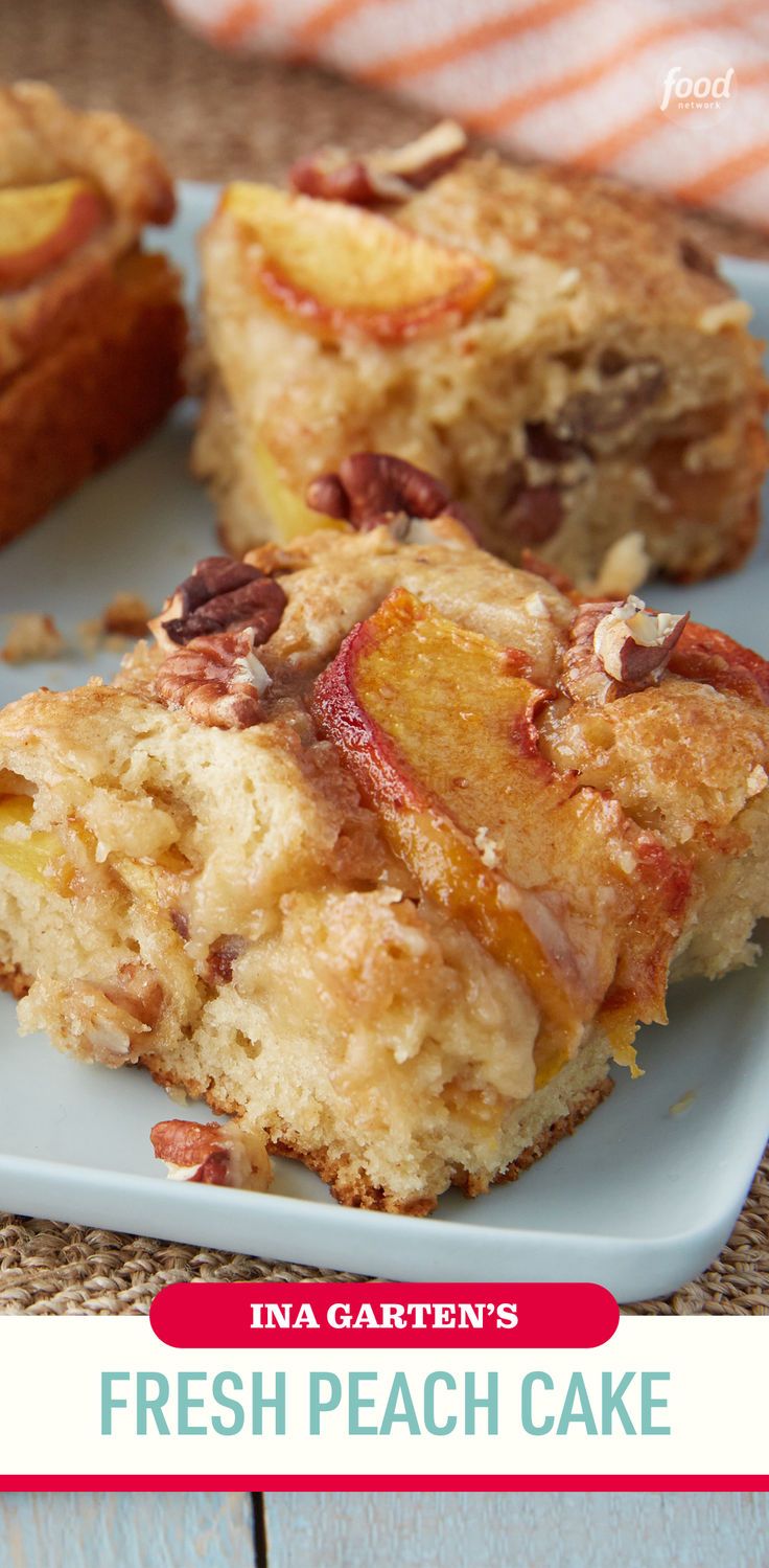 Close-up of a square slice of peach cake with visible peach slices and pecan pieces on top, on a light blue plate.