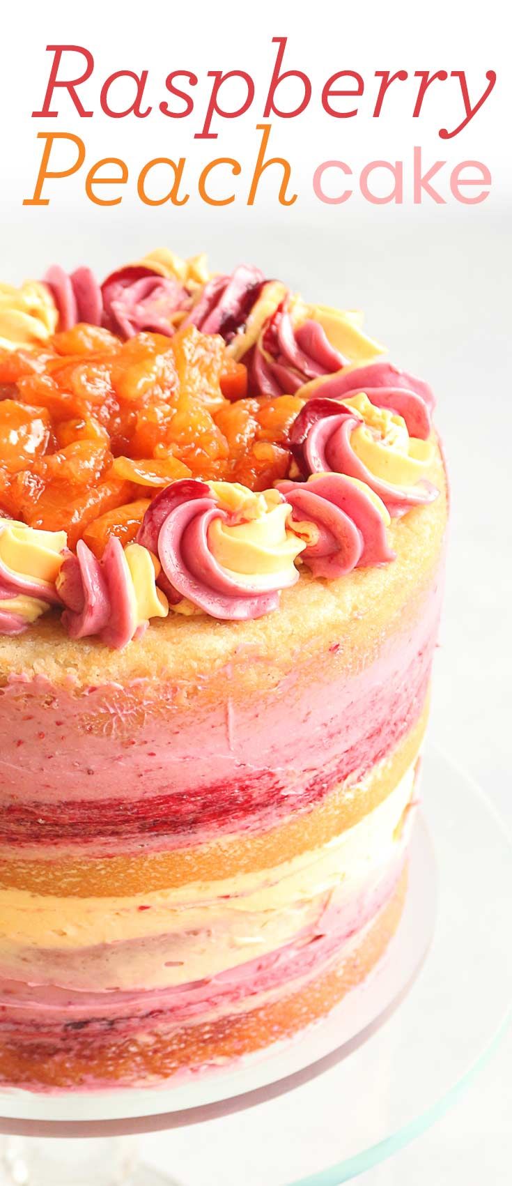 Decorative peach and raspberry cake with piped icing and fruit filling on top.