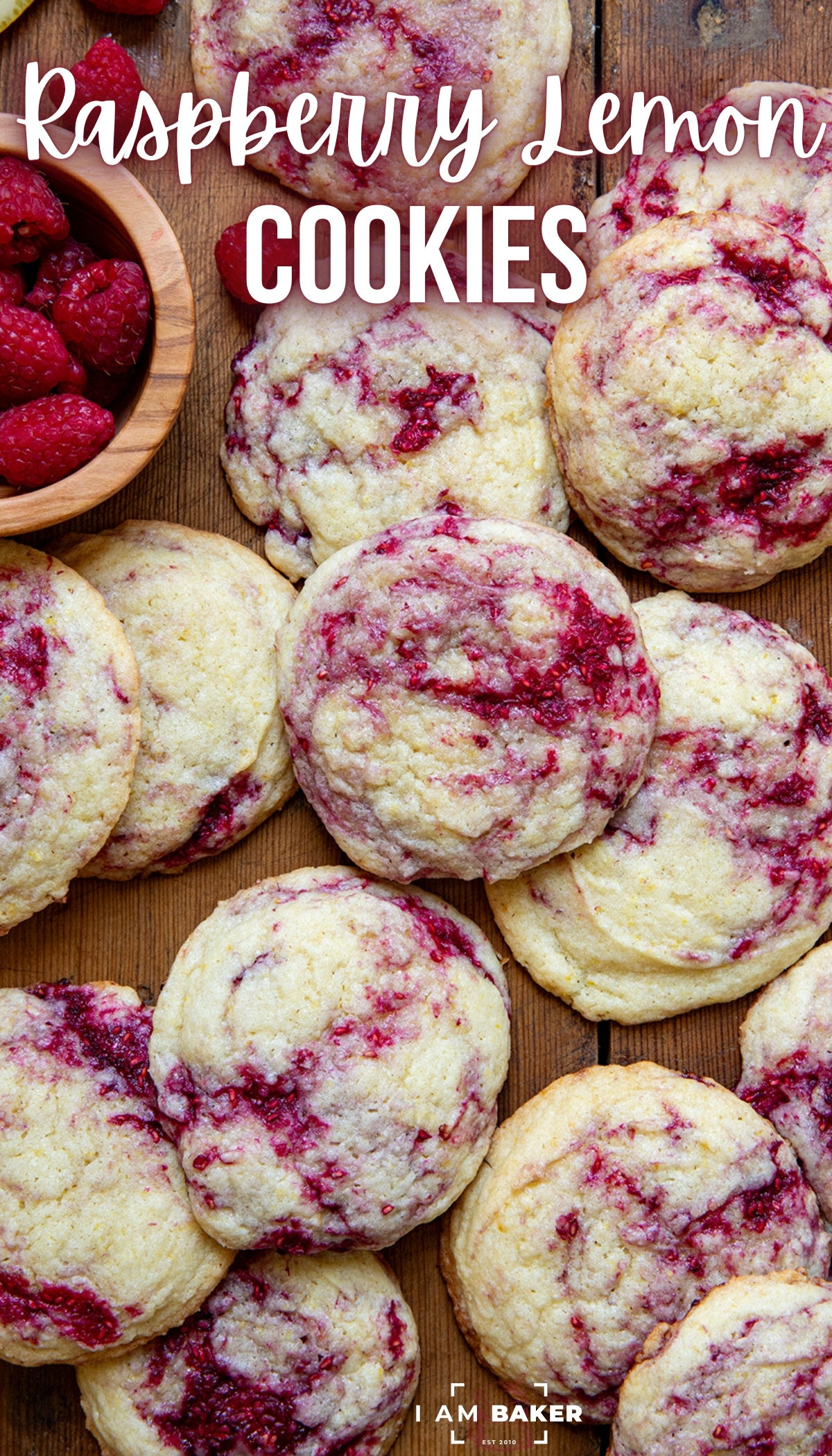 Close-up of raspberry lemon cookies with fresh raspberries in a small wooden bowl next to them