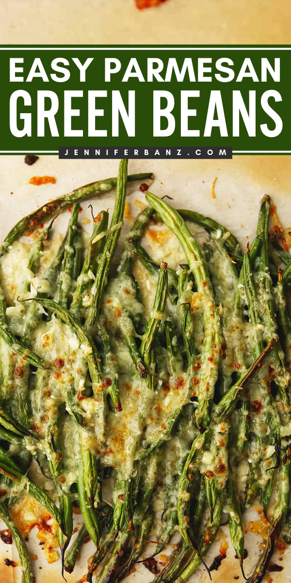 Baked green beans covered in melted Parmesan cheese, with some browning on the cheese.