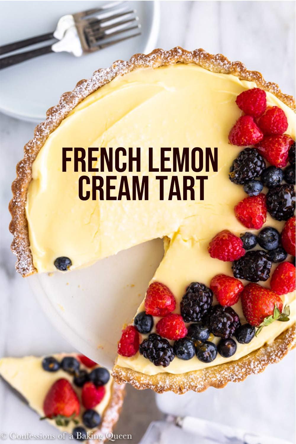Lemon cream tart with a slice removed, garnished with raspberries, blackberries, and blueberries.