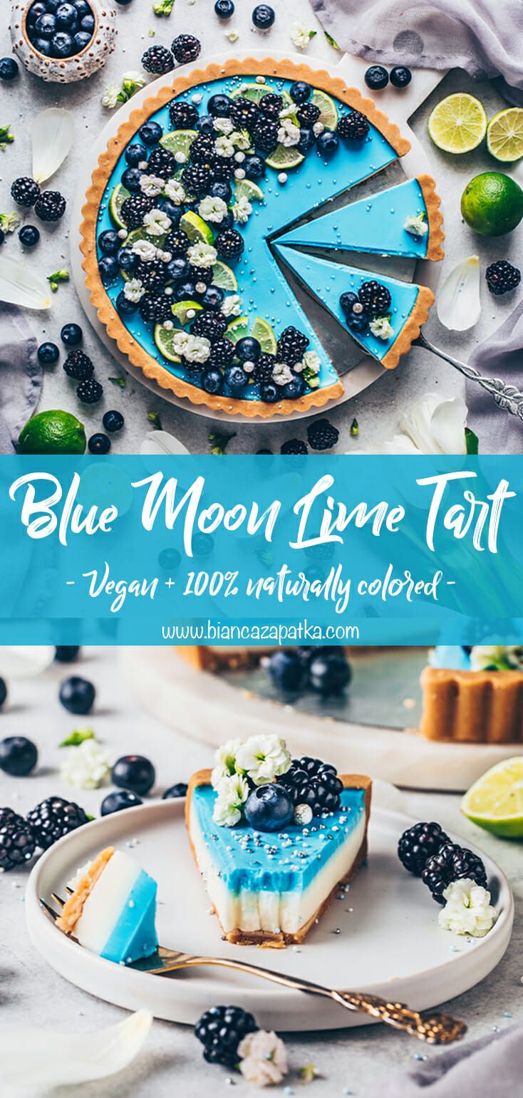 A whole round blue and white tart with slices removed, topped with blackberries, blueberries, lime slices, and edible…