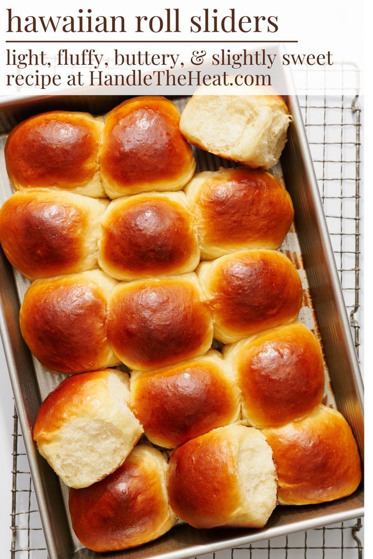 Baked Hawaiian rolls in a rectangular metal baking pan, with one roll slightly separated to show its fluffy interior.