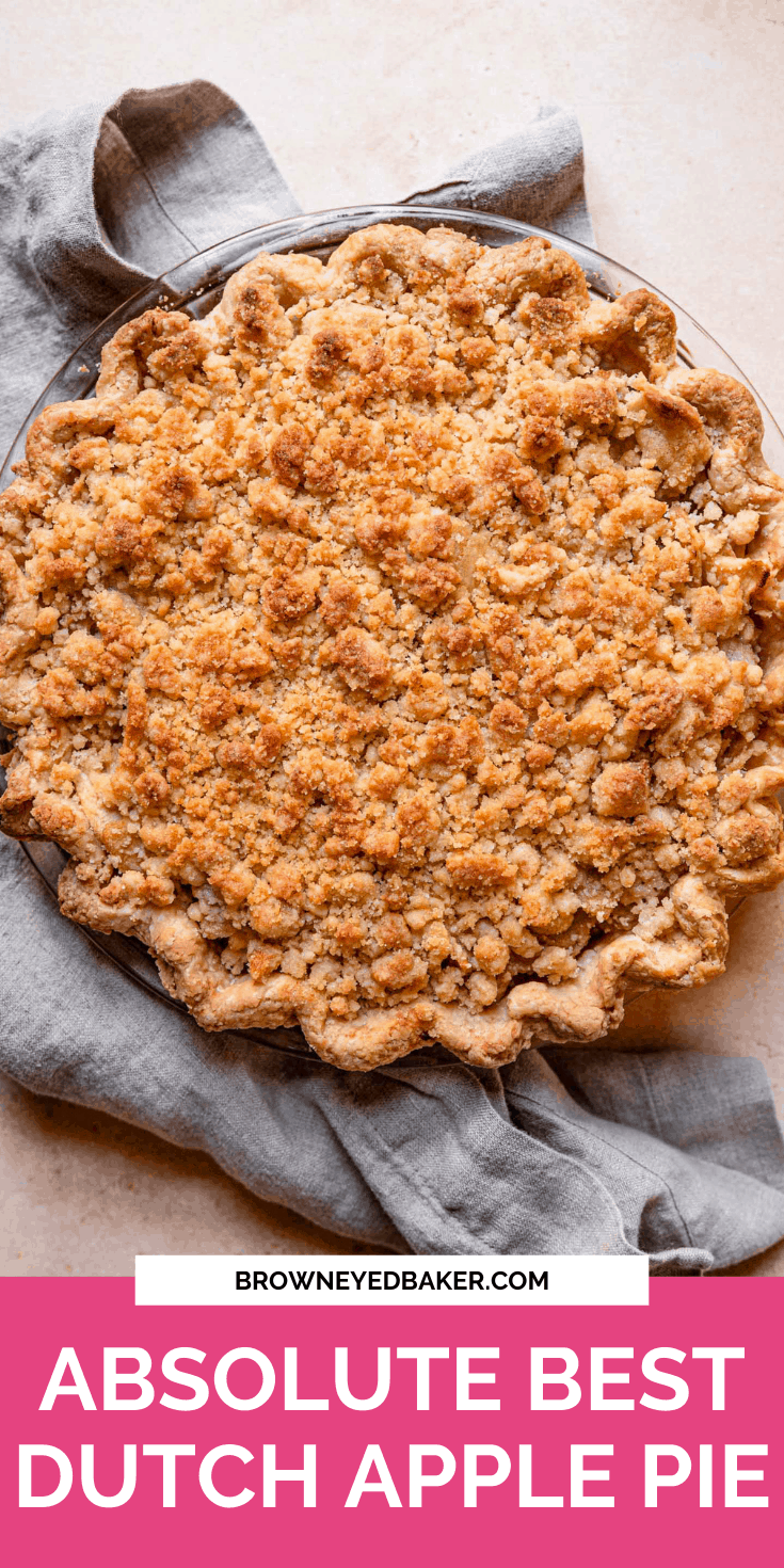 Close-up of a whole Dutch apple pie with a golden-brown crumb topping in a glass pie dish
