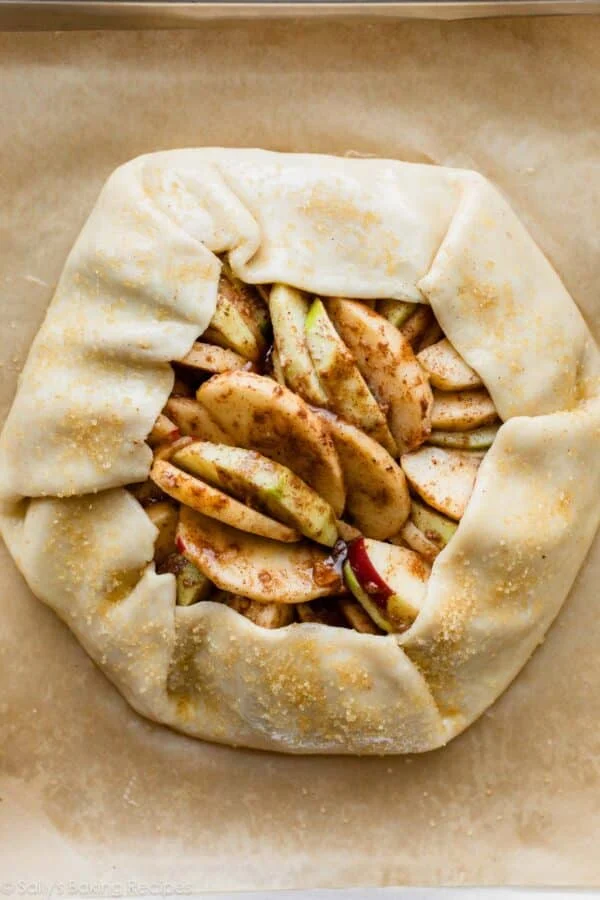 Unbaked apple galette with dough folded around sliced apples