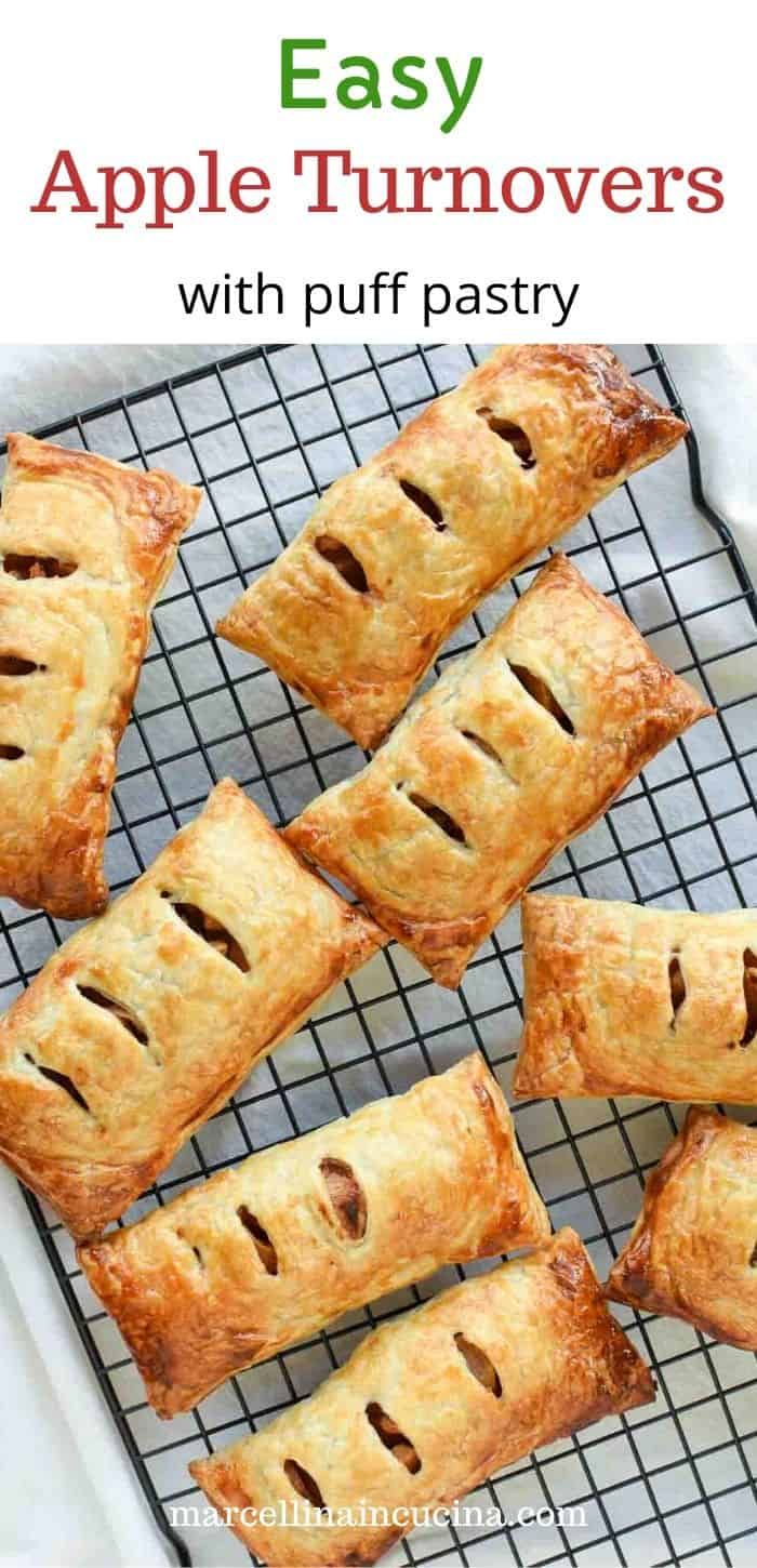 Several golden brown apple turnovers on a black cooling rack, showing their flaky crusts and vent slits.