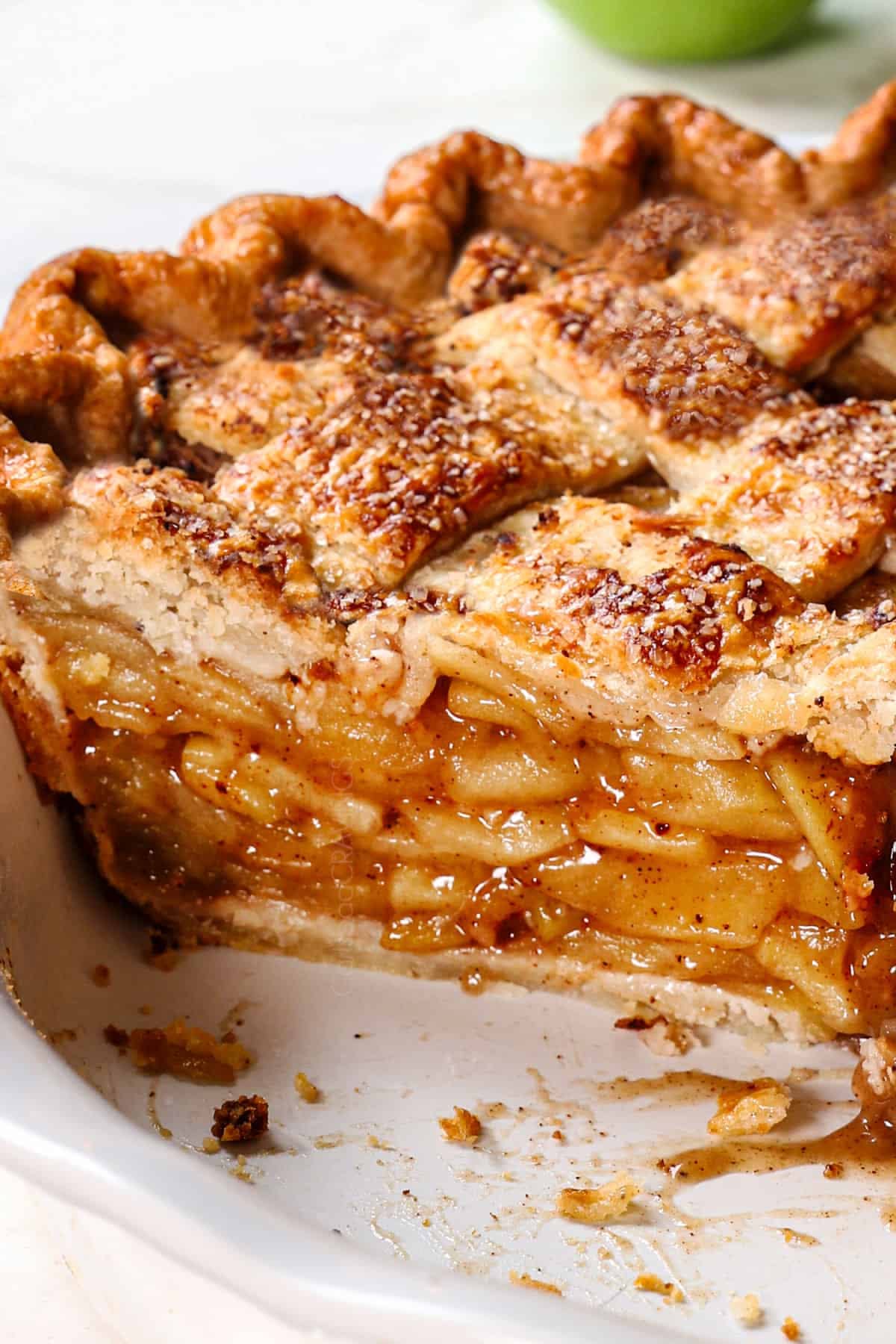 Close-up of a homemade apple pie slice, showing the lattice crust and layered apple filling.