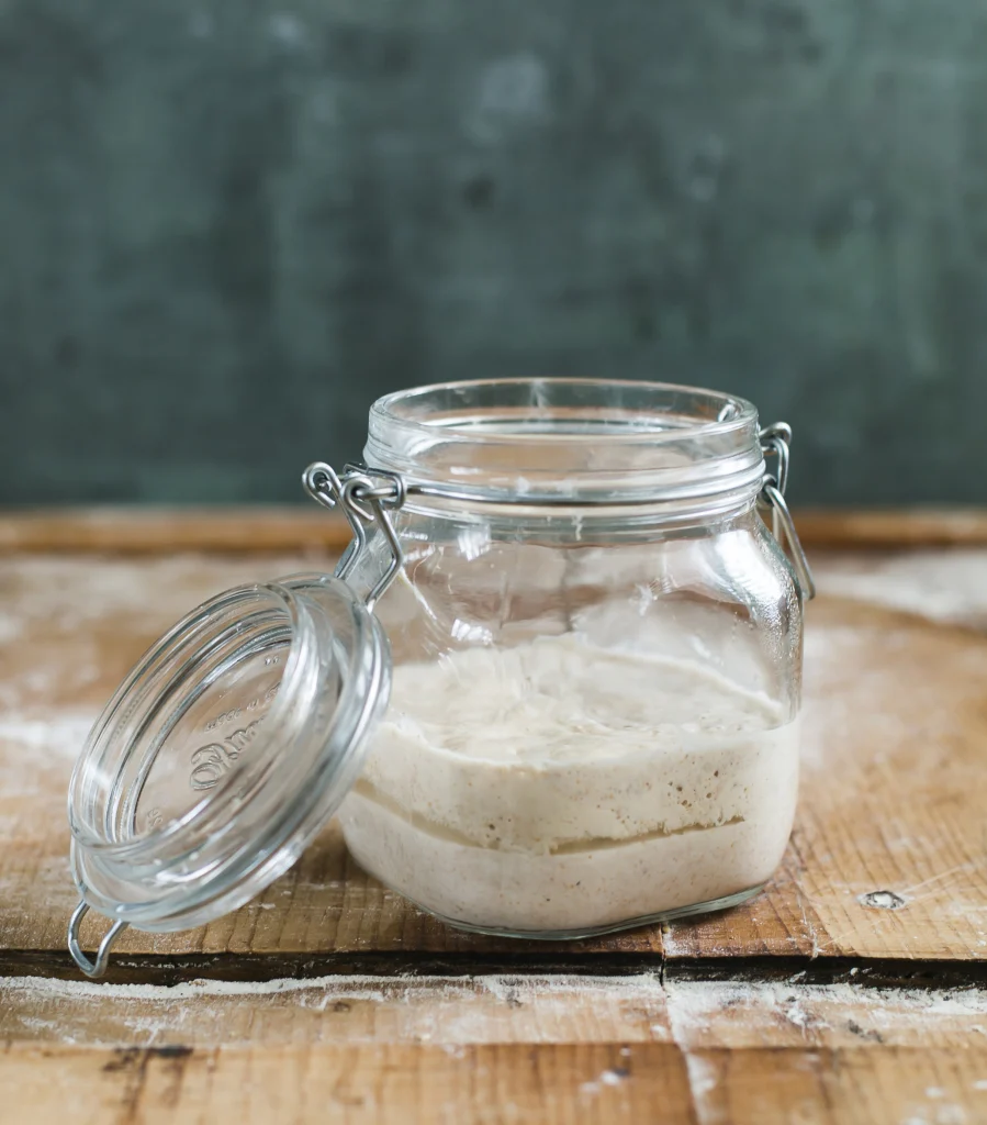 Sourdough starter with visible bubbles in a glass jar