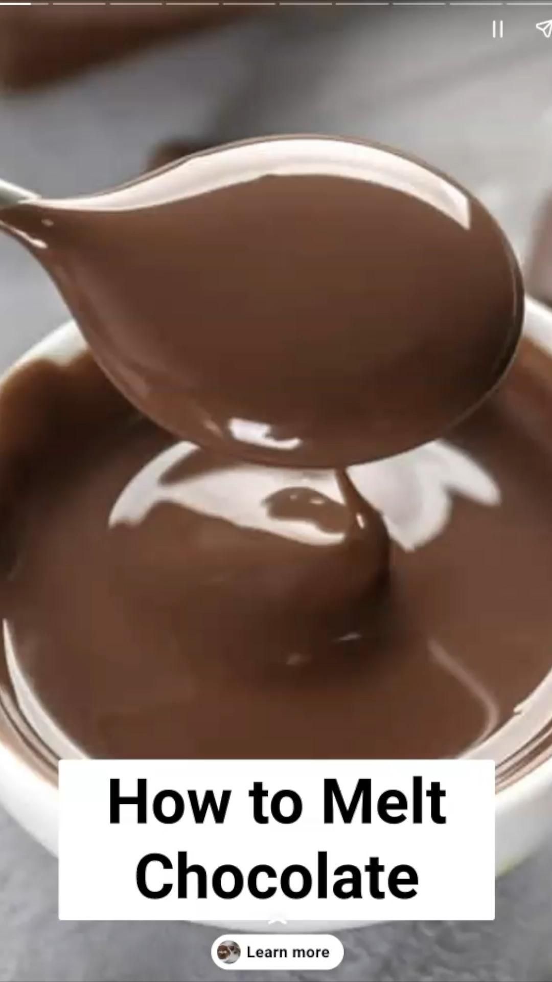 Close-up of a spoon lifting smooth, melted chocolate from a bowl, showing its glossy texture.