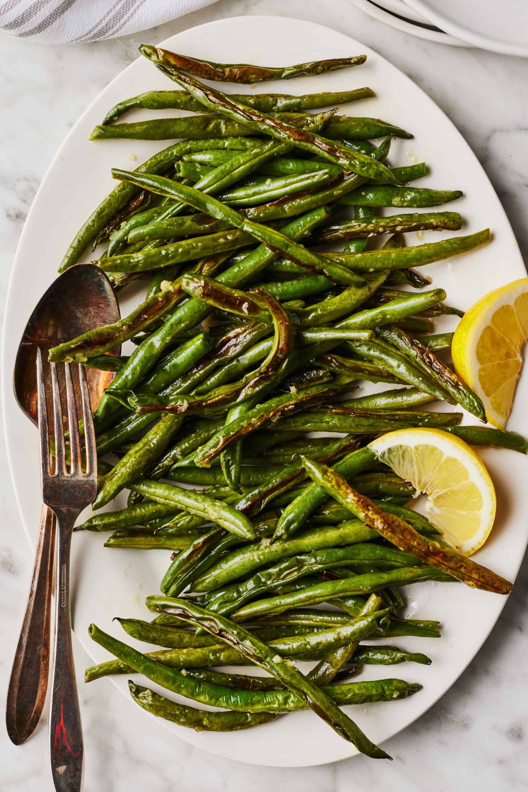 Roasted green beans in a white serving bowl