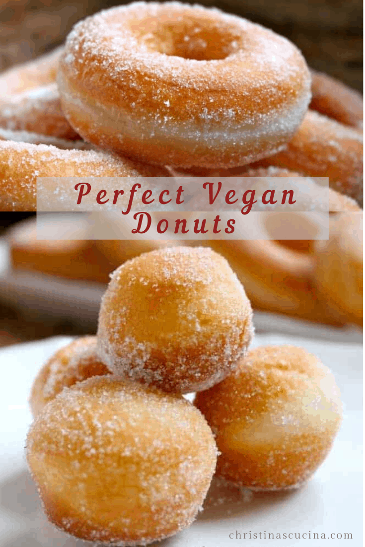 Close-up of sugar-coated doughnuts, some ring-shaped and some round donut holes, piled on a white plate.