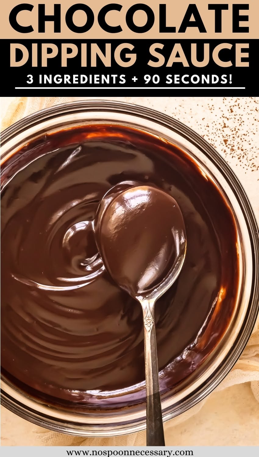 Close-up of shiny, dark chocolate sauce in a glass bowl, with a silver spoon scooping some sauce.