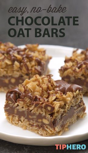 Three chocolate oat bars with a thick chocolate layer and an oat crumble topping, on a white plate.